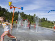 Children play in the spray park during a recent summer at Klineline Pond.