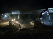 Construction crews use heavy machinery to rip out a freeway onramp that passes over Interstate 205 near Northeast 20th Avenue on Wednesday night in Salmon Creek.