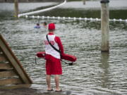 A lifeguard keeps watch over Klineline Pond at Salmon Creek Regional Park on Wednesday. Klineline Pond was closed indefinitely Thursday after routine testing showed elevated levels of E. coli bacteria.