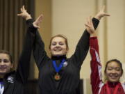 Heritage gymnast Britni Atwell celebrates after receiving the gold medal in the 4A Individual All Around state competition in Tacoma today.