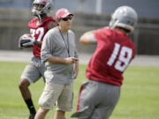 Washington State head coach Mike Leach, center, watches wide receivers Brett Bartolone, right, and Bobby Ratliff, left, run drills during on the first day of fall camp last week.