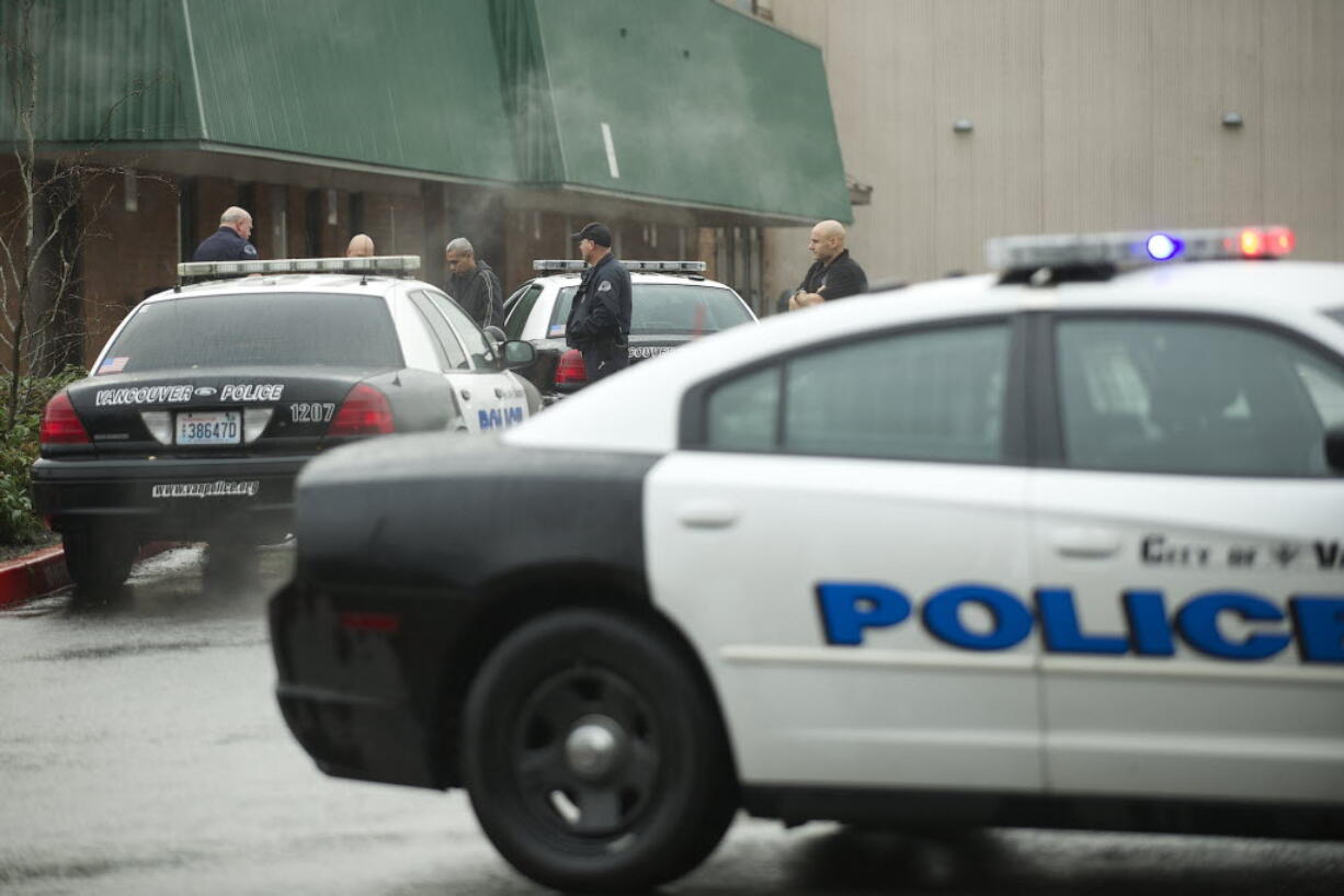 Vancouver Police officers confer outside Evergreen High School on Dec. 12 in Vancouver after a student was accused of bringing a gun to school and leaving it in a classroom.