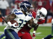 Seattle Seahawks running back Christine Michael (33) runs as Arizona Cardinals outside linebacker Alex Okafor (57) pursues during the first half of an NFL football game, Sunday, Dec. 21, 2014, in Glendale, Ariz. (AP Photo/Ross D.