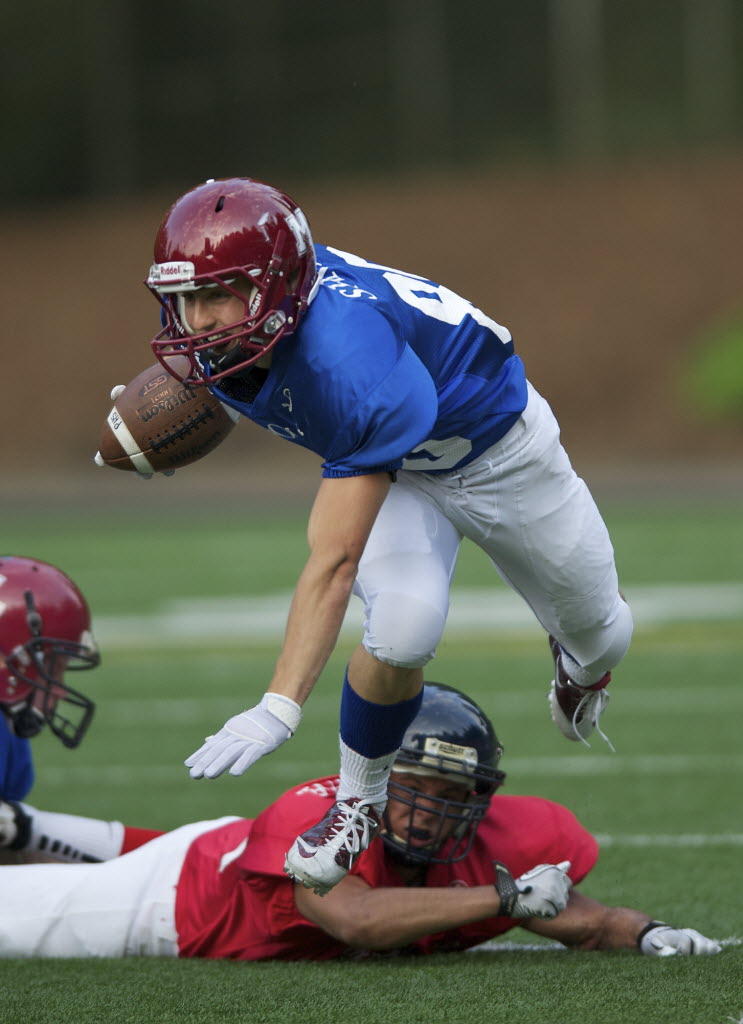 The West's Alex Mangin trips up the East's Jesse Zalk in the first half of the annual Freedom Bowl Classic at Kiggins Bowl on Saturday.