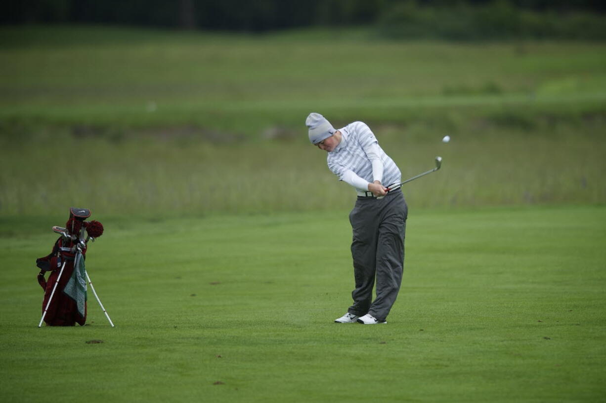 Brian Humphreys of Camas High School hits from the fairway on the fourth hole at Camas Meadows during the first round of the 4A state golf championship Tuesday.