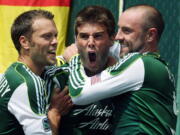 Portland Timbers' David Horst, center, is hugged by Jack Jewsbury, left, and Kris Boyd, right, after scoring in the first half Sunday against the Seattle Sounders.