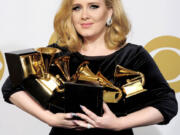 FILE - In this Feb. 12, 2012 file photo, Adele poses backstage with her six awards at the 54th annual Grammy Awards in Los Angeles. Adele won awards for best pop solo performance for &quot;Someone Like You,&quot; song of the year, record of the year, and best short form music video for &quot;Rolling in the Deep,&quot; and album of the year and best pop vocal album for &quot;21.&quot; After a year of Grammy glory and James Bond soundtracking, Adele has been voted The Associated Press Entertainer of the Year. (AP Photo/Mark J.