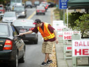 Clark County elections official Miguel Rivera takes ballots from motorists outside the Clark County Elections office Tuesday.