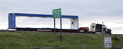 A truck that was carrying an oversize load sits parked southbound on Interstate 5 immediately south of the collapsed portion of the highway bridge at the Skagit River Friday, May 24, 2013, in Mount Vernon, Wash. The Washington State Patrol says the truck was hauling a too-tall load of drilling equipment from Canada to Vancouver, Wash., when it hit an overhead bridge girder on the major interstate between Seattle and Canada, sending a section of the span and two vehicles into the Skagit River Thursday evening.