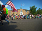 The Camas Days Grand Parade marches past the Public Library in 2012.