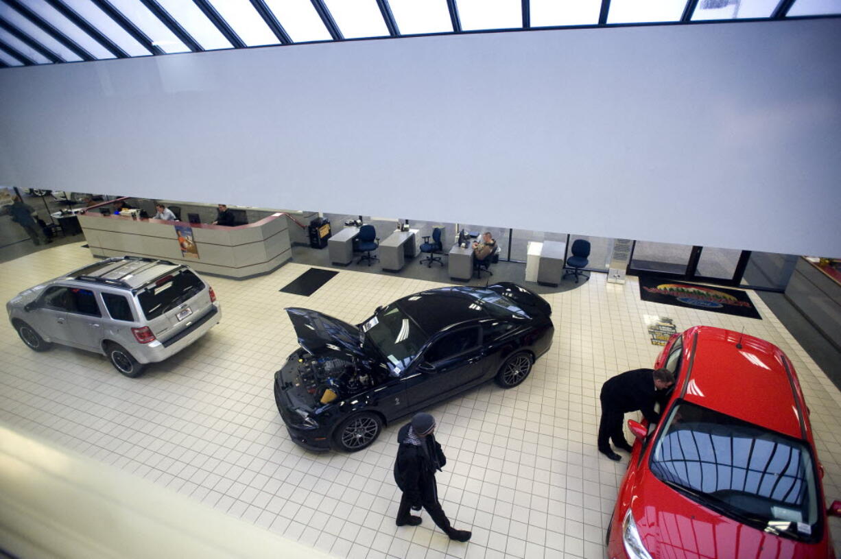 Sales personnel at Vancouver Ford wait to assist customers inside the showroom in January.