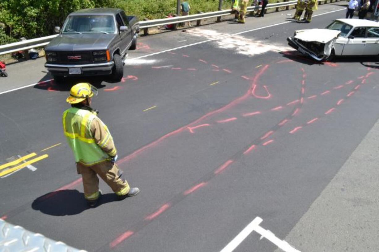 A firefighter surveys the scene of an injury crash that resulted in injuries to six people, including at least one from Vancouver.