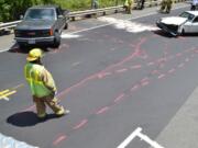 A firefighter surveys the scene of an injury crash that resulted in injuries to six people, including at least one from Vancouver.