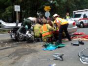 Rescuers aid a woman injured Thursday in a head-on collision near Daybreak Park.