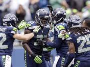 Seattle Seahawks' Kam Chancellor (31) is congratulated by teammates after intercepting against the Jacksonville Jaguars in the second half Sunday in Seattle.