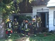 Firefighters work outside a house on the 14100 block of Northeast 72nd Avenue that caught fire on Saturday.