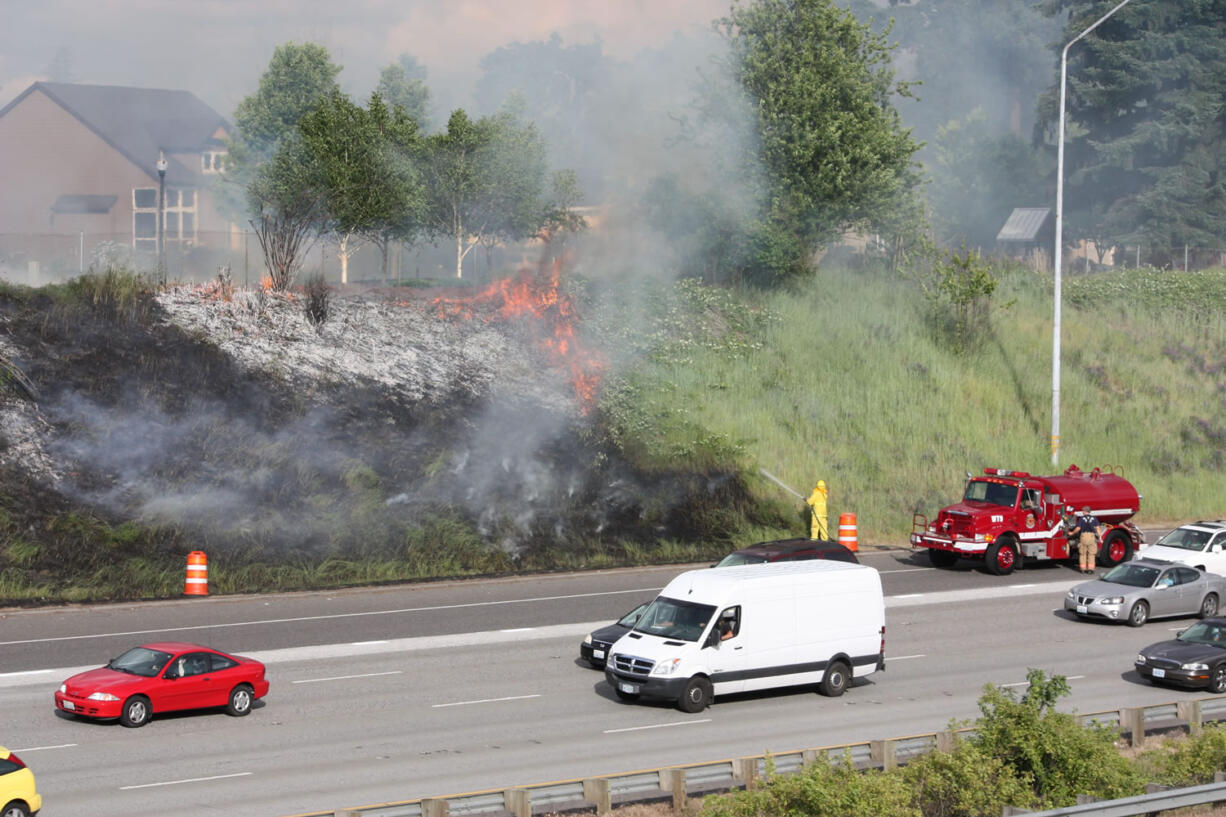 A grass fire beside Interstate 205 in Cascade Park spreads to the top of the bank Tuesday evening.