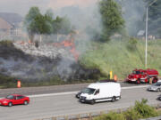 A grass fire beside Interstate 205 in Cascade Park spreads to the top of the bank Tuesday evening.