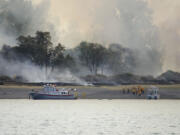 Firefighters arrive at Government Island Monday afternoon, Aug.