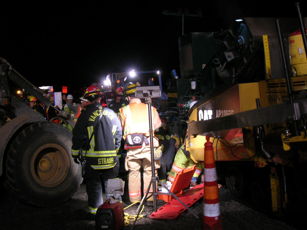 Firefighters on Thursday morning worked to free a construction worker who was critically injured after a paving machine backed over him on state Highway 500 near St.