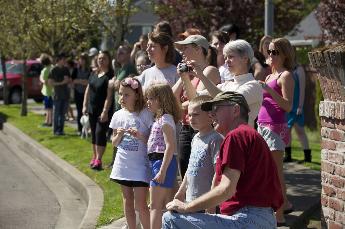 Bystanders watch as fire destroys an abandoned house near the intersection of N.E.