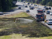 Firefighters with the Vancouver Fire Departmaent respond to a grass fire along Highway 14 eastbound at Exit 4 near Ellsworth Road in late June.