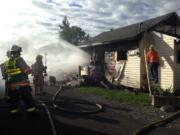 Firefighters battle a blaze in a house on S Street in Vancouver's Rose Village neighborhood late Wednesday afternoon.