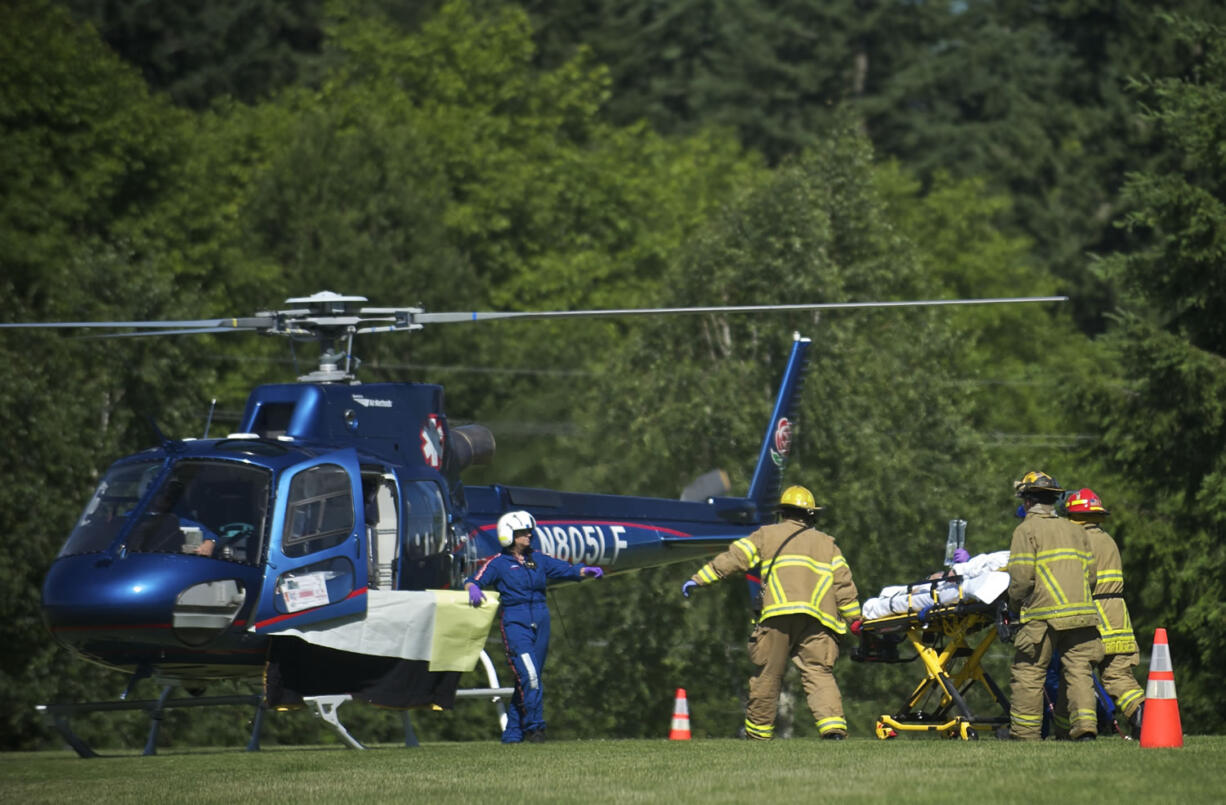 Firefighters load 9-year-old Addie Perrenoud onto a Life Flight helicopter at La Cetner High School after she suffered severe burns on Wednesday.