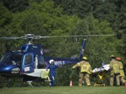 Firefighters load 9-year-old Addie Perrenoud onto a Life Flight helicopter at La Cetner High School after she suffered severe burns on Wednesday.