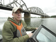 Environmental activist Bill McKibben passes under the Vancouver Railroad Bridge during a boat tour of  the Columbia River and the crude oil site proposed for the Port of Vancouver on Wednesday.