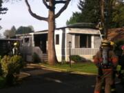 Firefighters battle a fire that damaged a mobile home on Friday at 5404 N.E. 121st Ave.