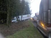 A tow crew assists a truck driver who ran off the road early today on Northeast 134th Street near Interstates 5 and 205.