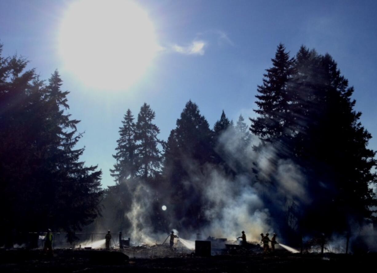 Firefighters mop up hot spots after a two-alarm brush fire broke out near the intersection of Northeast 49th Street and 137th Avenue.