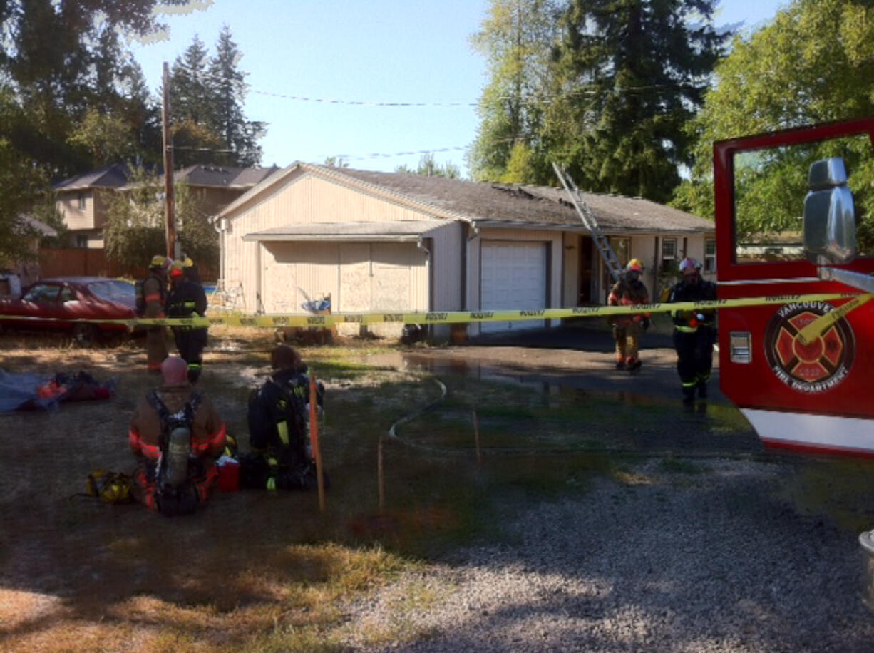 Firefighters take shelter from temperatures in the mid-90s while battling an attic fire in Vancouver's North Image neighborhood.