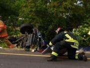 Firefighters on Tuesday extricated two people from a car that rolled on Interstate 205 near state Highway 500.