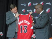 Portland Trail Blazers President Chris McGowan, left, holds a commemorative jersey with Moda Health President Dr.