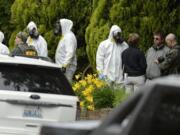 During the execution of a search warrant, members of the Joint Federal Haz-Mat Team, FBI, and local law enforcement gather in front of the Osmun Apartments on Saturday, May 18, 2013 in Spokane. The search warrant is in connection with ricin-laced letters intercepted at a Post Office facility in Spokane earlier in the week.