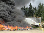 Firefighters battle a large tire fire in Ridgefield, estimated to be 50-feet by 50-feet.