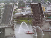 A Portland Fire Department fire boat shoots water into the air as it passes under the Morrison Bridge to celebrate the start of the Rose Festival fleet week Wednesday, June 8, 2011.