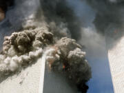 The south tower of the World Trade Center, left, begins to collapse after a terrorist attack on the landmark buildings in New York, Tuesday, Sept.