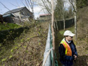 Cary Armstrong, source control specialist with the Clark County Department of Environmental Services, points out a poorly maintained stormwater site in a Vancouver neighborhood in 2011.