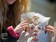 Columbia Way: Emma Lynn Scharff, 3, of Vancouver puts a paper snowflake over her face after her mother, Kelly Scharff, background, helped her cut it out of tissue on Jan.