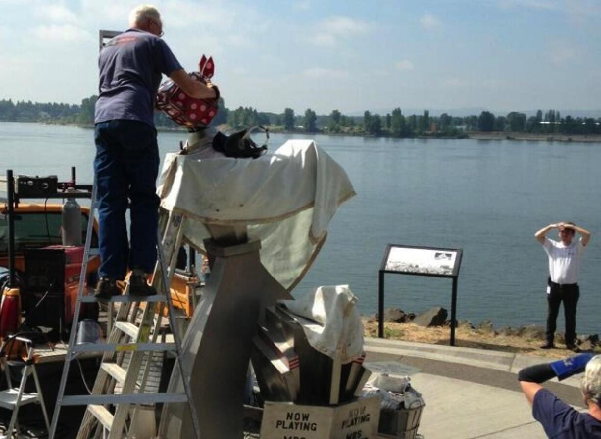 Dave Agnor places a new glass-and steel head atop the &quot;Wendy Rose&quot; statue overlooking the Columbia River late Tuesday morning.