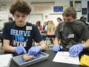 Biology students Gabe McMahon, left, and Michael Lovine dissect sheep brains at Skyview High School in 2015. NW Noggin, a nonprofit organization of volunteer neuroscientists, brought the sheep brains to the class for dissection. Lovine covered his face with his t-shirt to mask the smell.