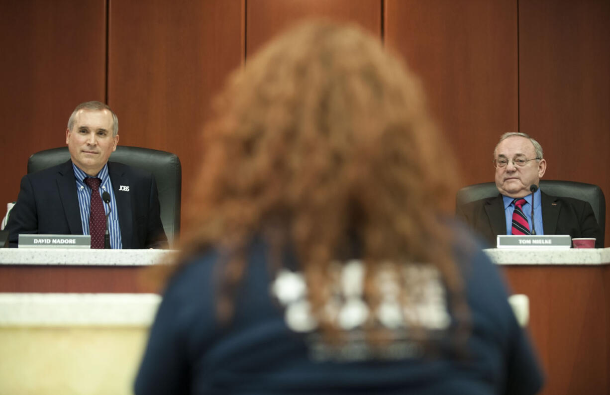 Clark County counciller David Madore and Tom Mielke listen to a woman speak at a council meeting in Vancouver on Feb. 24.