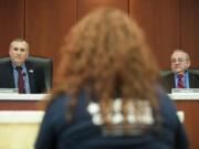 Clark County counciller David Madore and Tom Mielke listen to a woman speak at a council meeting in Vancouver on Feb. 24.