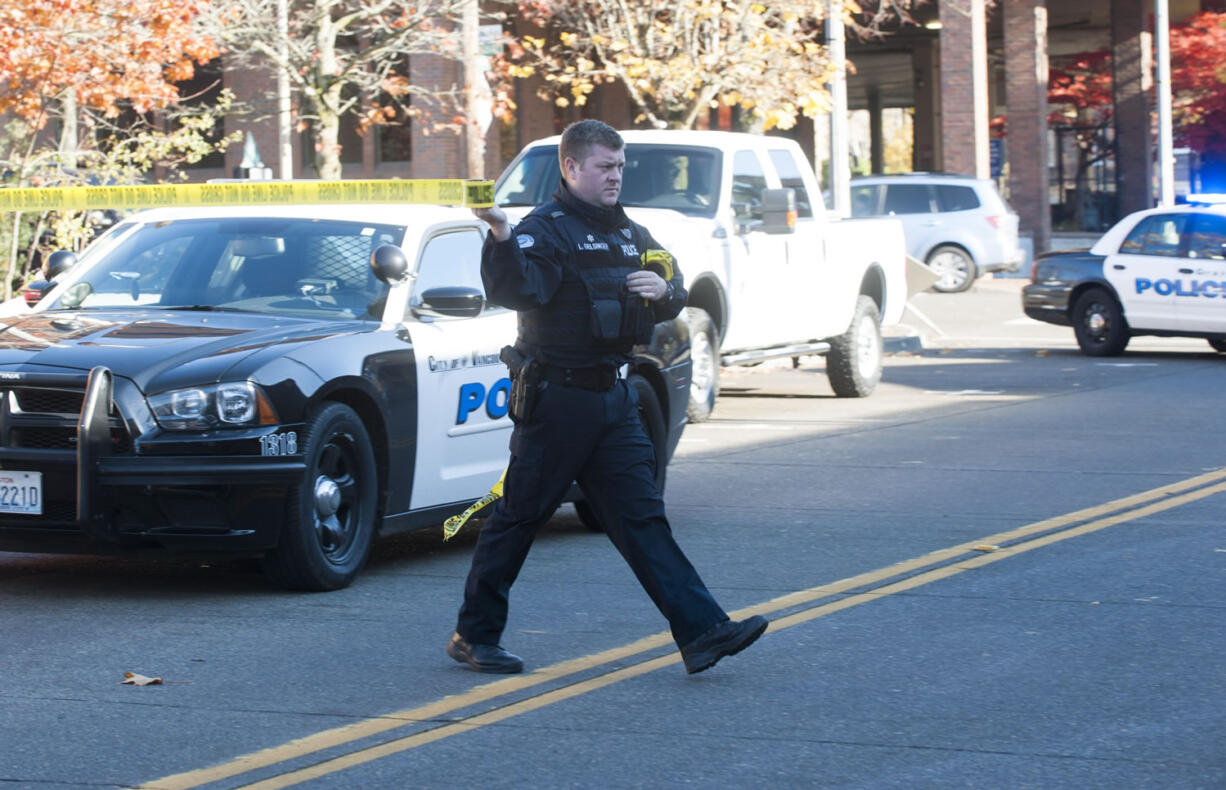 A Vancouver police officer puts up police tape at the scene of a crime in November. After working for a year without a contract, the Vancouver Police Officers' Guild and the city have reached an agreement, which the city council is expected to approve Monday.