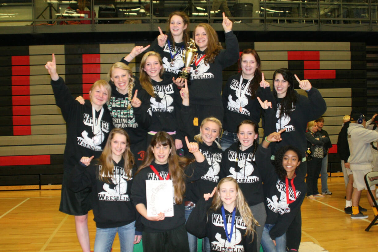 The Panther girls wrestlers stand on the podium