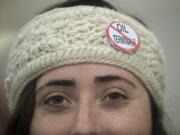 Erin Murdock wears a button indicating her opposition to building an oil transfer terminal, at the first public hearing on the matter Jan. 5 in Vancouver.