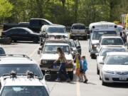 School counselor Christine Grilli escorts two students to a waiting car at South Ridge Elementary School in Ridgefield in May.